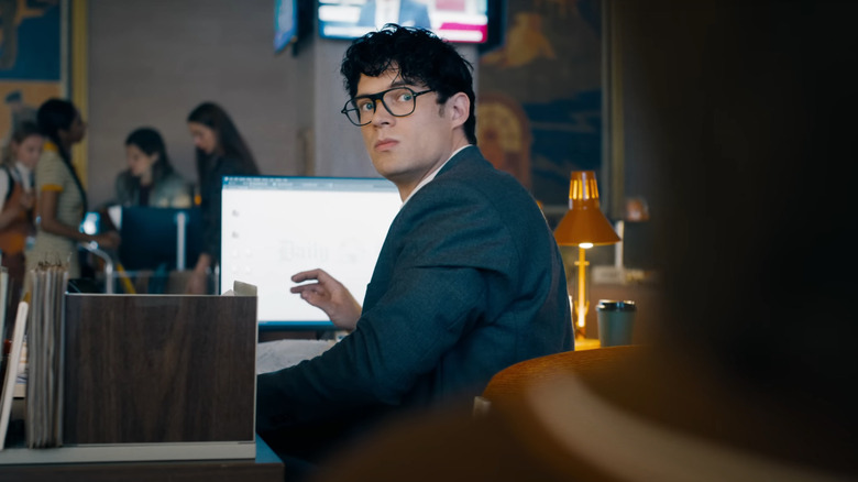 David Corenswet as Clark Kent sitting at his desk at the Daily Planet in Superman (2025)