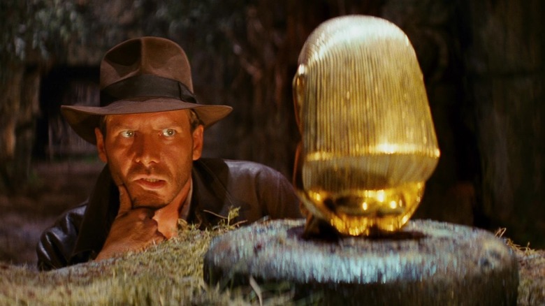 Harrison Ford's Indiana Jones looking at the idol in the opening of Raiders of the Lost Ark