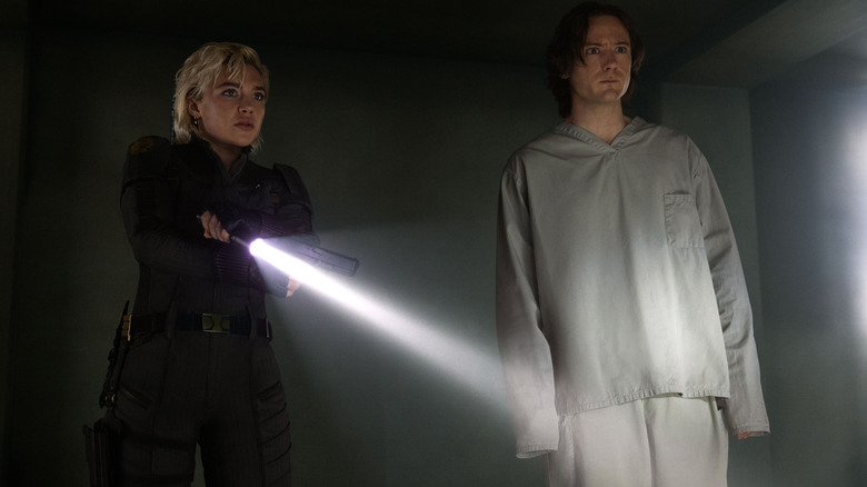 Florence Pugh as Yelena Belova and Lewis Pullman as Bob standing in a dark hallway in Thunderbolts